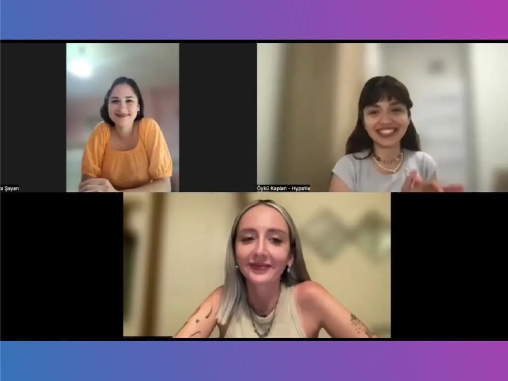 Genç bir kadın bilgisayar başında gülümsüyor